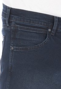 Ciemnoniebieskie dżinsy denimowe z klasycznym wzorem pięciu kieszeni. Charakteryzują się kontrastującym przeszyciem i metalowym guzikiem zapinanym w pasie.