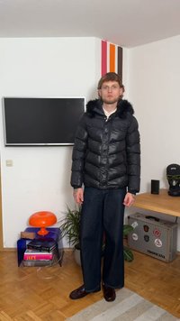 Μαύρο φουσκωτό μπουφάν με κουκούλα επενδυμένη με γούνα, με κεντητό σχέδιο και μπροστινό φερμουάρ. Συνδυασμένο με τζιν παντελόνι φαρδιάς γραμμής και σκούρα παπούτσια.