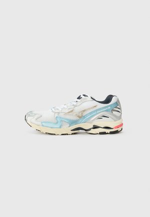 Baltas skriešanas apavs ar aculietojuma augšdaļu, sudraba un gaiši zila akcenti, melna zole un krēmkrāsas starpzole, ar auklām un logotipa detaļu.