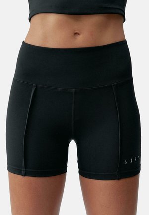 Pantalones cortos deportivos negros con una cinturilla alta, hechos de una tela suave. Presenta detalles de costura y un logo en un color contrastante.