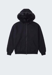 Sweat à capuche noir zippé avec poches avant et capuche doublée d'une épaisse bordure en fausse fourrure noire, présenté sur un fond clair uni.
