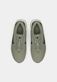 Chaussures de sport en maille vert olive avec des accents noirs. Elles présentent un bout arrondi, un design à lacets et une semelle blanche. Style minimaliste.