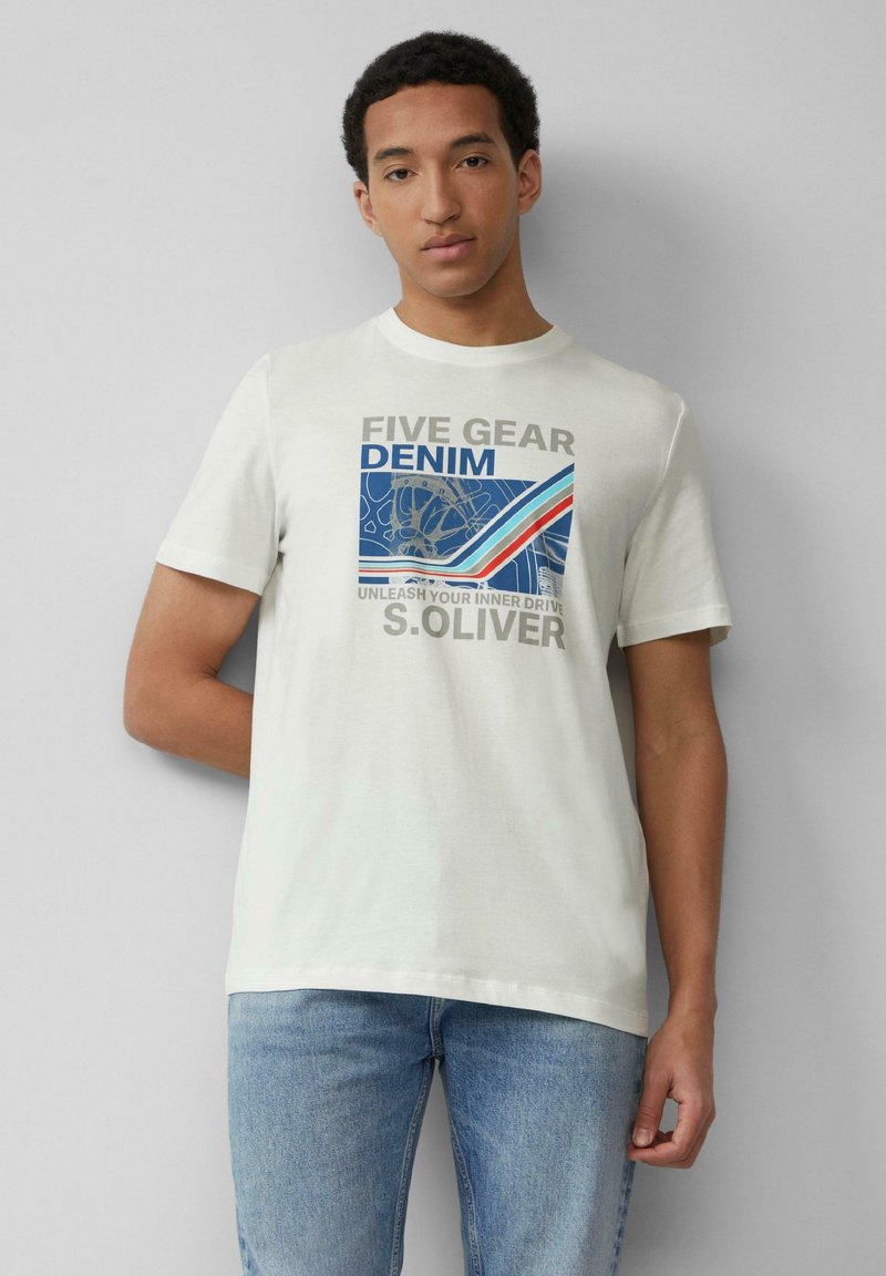 Biała bawełniana koszulka z graficznym nadrukiem z napisem "FIVE GEAR DENIM" w szarych i niebieskich akcentach. Połączona z jasnoniebieskimi dżinsami.