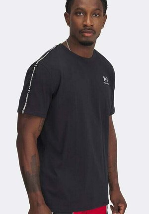 Camiseta negra de manga corta hecha de algodón, con un escote redondo, logotipo en el pecho y acentos de texto blanco en las mangas.