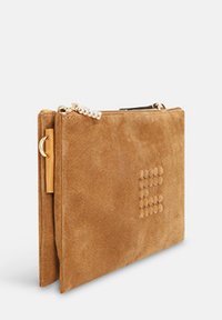 Beige faux-suède clutch met een geperst stippenpatroon, ritssluiting en een gouden kettingaccent. Rechthoekige vorm met een zachte textuur.