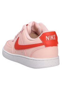 Sneaker in pelle rosa con accenti rossi, dotata di un colletto imbottito e suola in gomma bianca. Logo Nike sul tallone e sul lato in rosso.