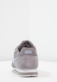 Grå mocka och mesh sneaker med ljusblå accent och vit sula; har "NIKE"-logotyp på baksidan och en vadderad krage.