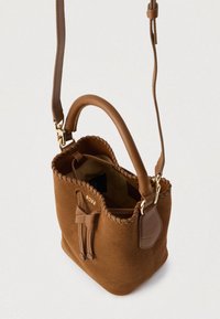 Καφέ τσάντα κάδου από σουέντ με δερμάτινες λεπτομέρειες, ραμμένη τρέσα και επάνω χερούλι. Περιλαμβάνει αποσπώμενο ιμάντα ώμου και εσωτερική τσέπη.