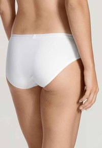 Slip di cotone bianco con una texture liscia, design a vita media e taglio minimalista. La vista posteriore mostra una finitura senza cuciture e una cintura morbida.