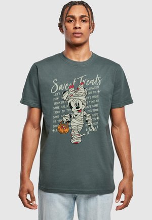 Dark grey t-shirt featuring a cartoon character wrapped in bandages, holding an orange pumpkin bucket, with text in cream color.