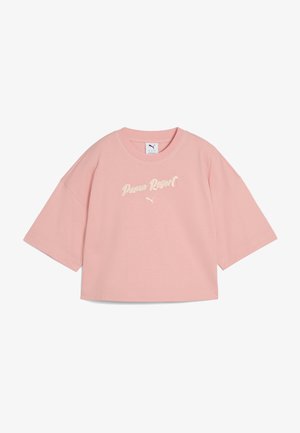 T-shirt court rose en coton doux, avec un col rond et des manches surdimensionnées. Texte "Puma Resort" brodé en couleur claire.