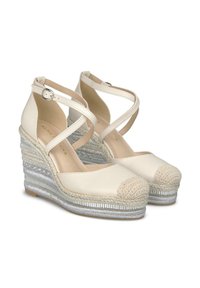 Witte espadrille wedges met een gevlochten textuur, voorzien van een ronde neus, kruisbandontwerp en metallic accenten op de hak.