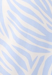 Tessuto in fibra con un motivo a strisce zebra azzurro chiaro e bianco, dalla texture liscia e con una leggera lucentezza.