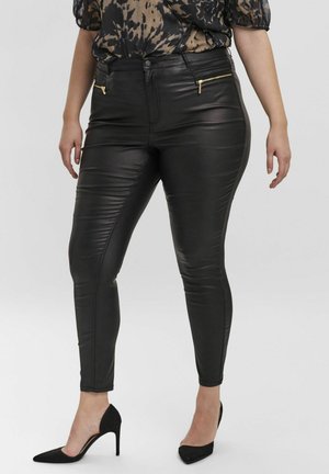Jeans skinny en simili cuir noir avec poches avant zippées, texture lisse et coupe effilée, associés à des escarpins noirs à bout pointu.
