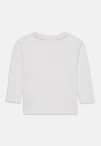 Hvit langermet topp med rund hals og rett kant. Mykt bomullsstoff med en jevn tekstur. Ingen synlige mønstre eller grafikk.