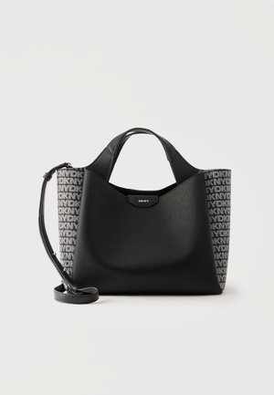 Czarna torebka DKNY z fakturowanym przodem, bokami z monogramowanego materiału, krótkimi uchwytami i odpinanym paskiem na ramię na białym tle.
