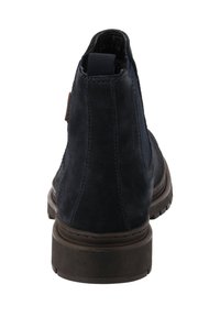 Granatowe zamszowe botki za kostkę z elastycznymi panelami bocznymi, teksturowaną gumową podeszwą oraz brązowym skórzanym akcentem na pięcie.