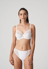 Witte kanten bh met semi-transparante panelen en verstelbare bandjes, gecombineerd met bijpassende bikini slipjes met kanten accenten aan de zijkanten.
