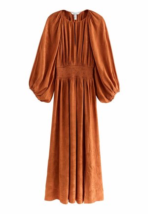 Long, rust-colored dress made of textured fabric with puff sleeves, a smocked waist, and a subtle leaf pattern throughout.