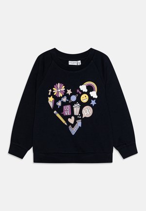 Sort langærmet skjorte med farverigt hjerteformet design med blomst, regnbue, smiley, popcorn, blyant, stjerner og teksten "LOVE" og "Hi."