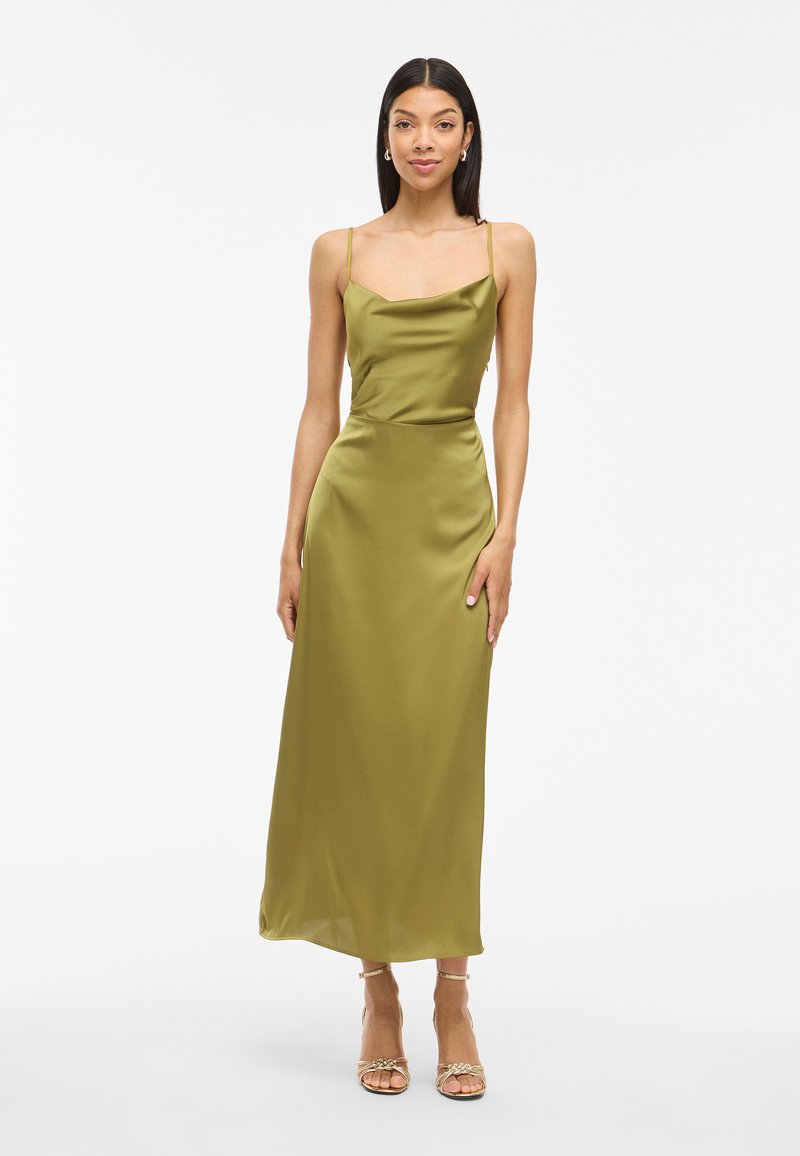 Satin olive-green spaghetti strap dress with a straight neckline, fitted waist, and ankle-length hem. Model wears strappy gold heels.
