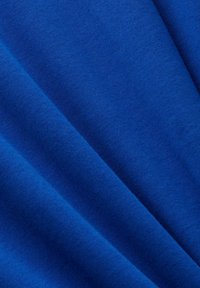 Tessuto blu con una superficie liscia, caratterizzato da una leggera lucentezza e morbide pieghe. Il colore è vivido con saturazione consistente.