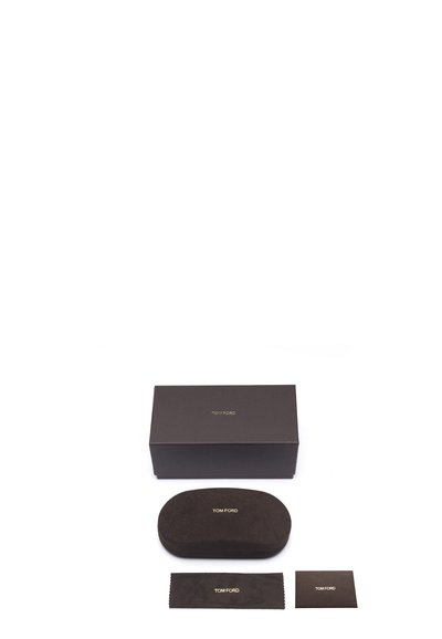 Tom Ford black cardboard box, oval soft case, cleaning cloth, and card with gold text, all featuring a smooth matte texture.