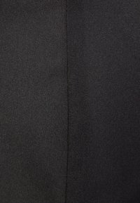 Tissu noir avec une texture lisse, présentant un motif de tissage subtil et un détail de couture verticale. Pas d'embellissements ni d'accents discernables.