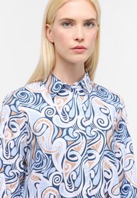 Camicia button-up con un motivo vorticoso blu, bianco e beige. Realizzata in tessuto morbido, presenta un colletto a punta e una leggera lucentezza.
