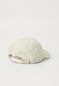 Witte stoffen pet met een geometrisch patroon en een Calvin Klein-label aan de achterkant, met een gebogen klep en een verstelbare band.