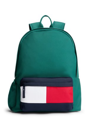 Zaino verde con spallacci imbottiti e tasca frontale con cerniera con design a blocchi di colore orizzontali bianco, rosso e blu navy.