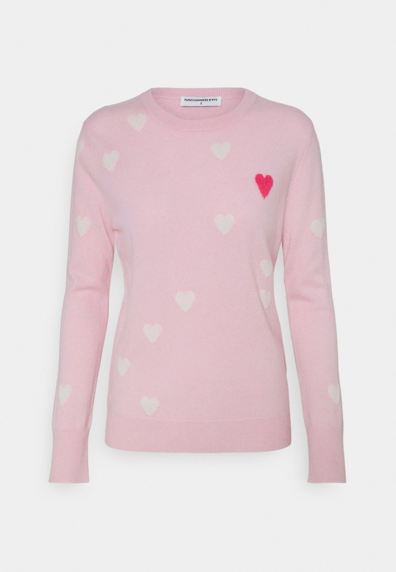 Pull rose clair à manches longues, décoré de petits cœurs blancs et d'un cœur rouge proéminent sur la poitrine gauche.