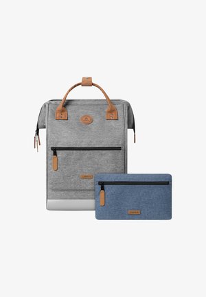 Grijze stoffen rugzak met leren accenten, ritszakken en een afneembare blauwe pouch. Heeft een minimalistisch ontwerp en ronde logo-details.