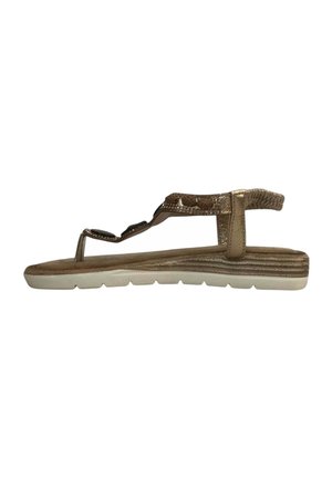 Flat sandal with beige sole and gold strap featuring decorative black stones and a back elastic strap for support.