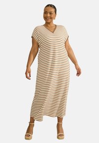 Abito maxi a righe con scollatura a V, maniche corte e vestibilità ampia. I colori includono crema e marrone. Indossato con sandali platform color beige.