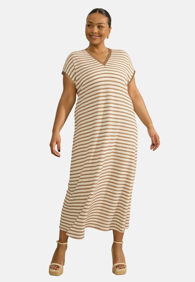 Abito maxi a righe con scollatura a V, maniche corte e vestibilità ampia. I colori includono crema e marrone. Indossato con sandali platform color beige.