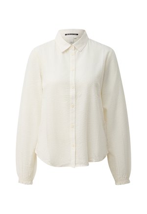 Blouse blanche à manches longues texturée avec boutons sur le devant, col classique et poignets élastiqués.