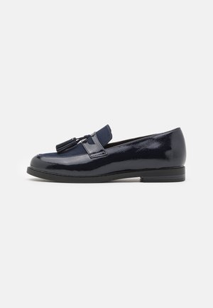 Blank mørkeblå loafer med kvaster, lav hæl og rundet tå, vist fra siden på hvid baggrund.