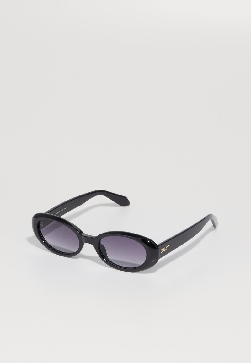 Óculos de sol pretos em forma oval com lentes roxas em degradê. Armação e hastes em plástico brilhante. Logótipo dourado na haste esquerda.