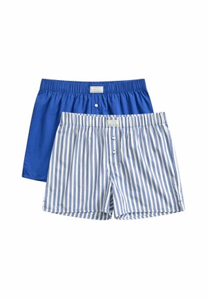 Deux paires de boxers pour homme, un bleu uni et un blanc avec des rayures verticales bleues, tous deux avec une ceinture élastique et des boutons à l'avant.