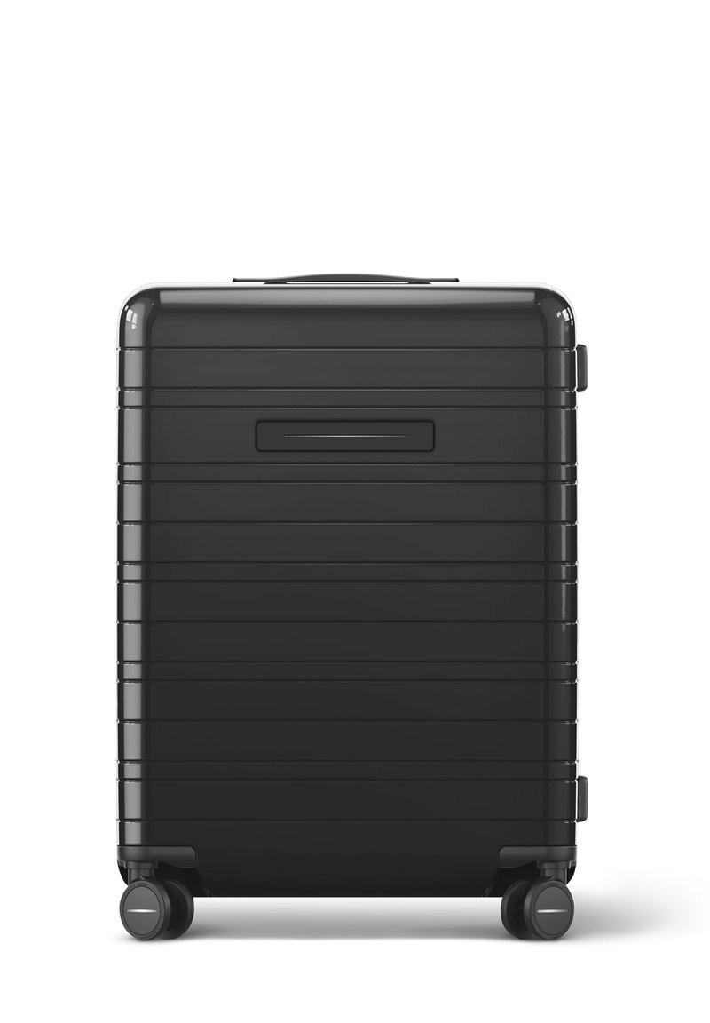 Black hard-shell suitcase with horizontal ribbed design, a top handle, and two wheels. Features a recessed ID slot on the back.