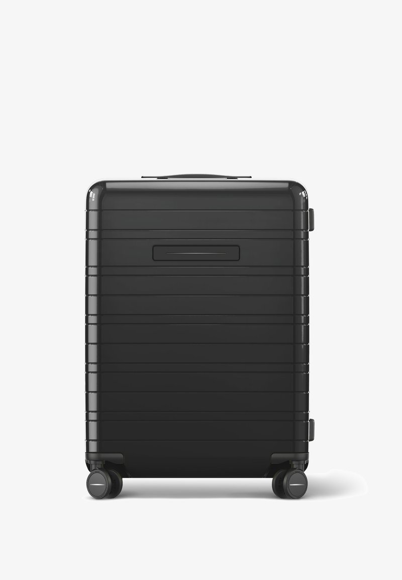 Schwarzer Hartschalenkoffer mit horizontal geripptem Design, einem oberen Griff und zwei Rädern. Verfügt über einen vertieften ID-Slot auf der Rückseite.