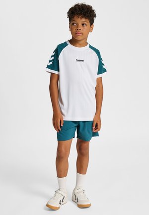 Wit sportshirt met korte mouwen, turkooizen accenten en strepen, gecombineerd met turkooizen korte broek en witte sportsokken; met een logo op de borst.