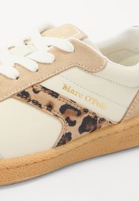 Beige és krém színű sneaker leopárdmintás kiegészítőkkel, velúrból és bőrből készült, fehér fűzőkkel és arany márkalogóval. Gumitalp, texturált tapadással.