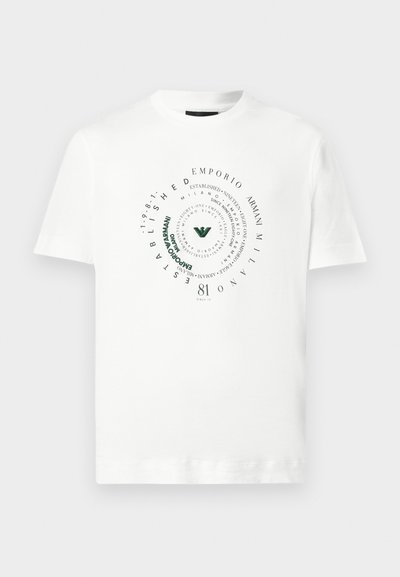 Λευκό κοντομάνικο T-shirt με κυκλικό σχέδιο σπείρας κειμένου που περιλαμβάνει τις φράσεις "Emporio Armani Milano", "Established 1981" και ένα πράσινο στιλιζαρισμένο λογότυπο στο κέντρο.