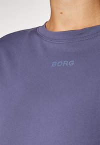 Korteermet marineblå t-skjorte laget av myk bomull, med rund hals og subtil "BORG" logo i en lysere nyanse på brystet.