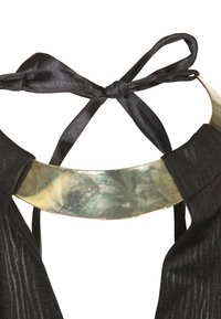 Top in tessuto nero con colletto dorato lucido. Presenta una chiusura a fiocco sul retro, mettendo in evidenza una finitura elegante e liscia con una leggera texture.
