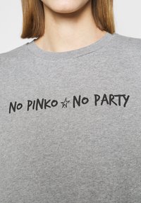 Grijze sweatshirt met een ronde hals, met zwarte tekst "NO PINKO NO PARTY" en een kleine sterrenafbeelding. Zacht, textuurstof.