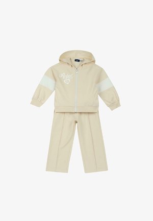 Ensemble survêtement beige pour tout-petit avec veste à capuche zippée ornée de bandes blanches sur les manches et texte "Rebel 58", accompagné d'un pantalon assorti.