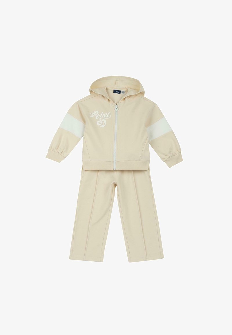 Ensemble survêtement beige pour tout-petit avec veste à capuche zippée ornée de bandes blanches sur les manches et texte "Rebel 58", accompagné d'un pantalon assorti.